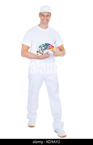Portrait Of Male Painter With Swatch Book Showing Thumb Up Stock Photo