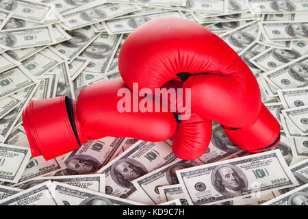 Boxing gloves on top of 100 dollars bills Stock Photo