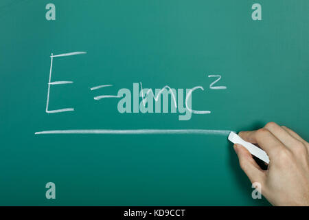 Hand writing relativity formula on green blackboard Stock Photo