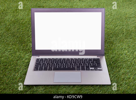 Silver Laptop Placed On Green Grass Field Stock Photo