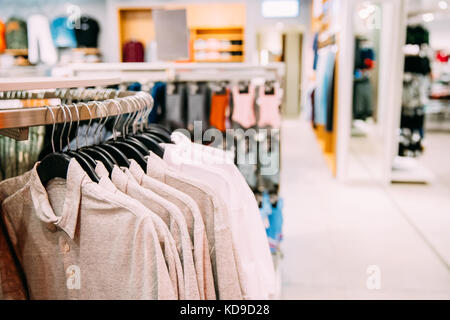 Many One-colour Polo Shirt On Hanger In Store Of Shopping Center. Stock Photo