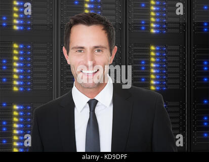 Photos of businessman standing in front of server racks Stock Photo