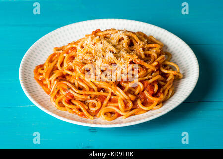 Plate of Spaghetti Pasta In Tomato Sauce With Grated Parmeson Cheese on a Wooden Blue Background Stock Photo