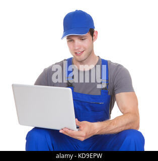 Portrait Of Happy Mechanic Holding Laptop On White Background Stock Photo