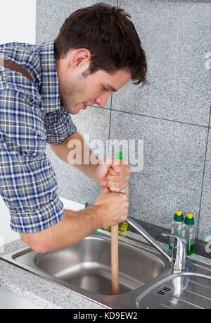 Man Using a Plunger to unstop his bathroom sink 4817267 Stock Photo at  Vecteezy