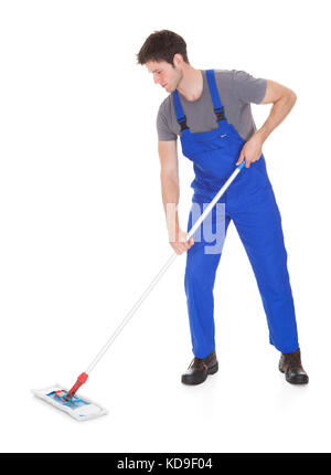 Young Man In Blue Uniform Cleaning The Floor Over White Background Stock Photo