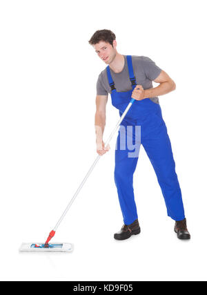 Young Man In Blue Uniform Cleaning The Floor Over White Background Stock Photo