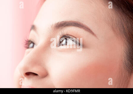 Beautiful asian woman eye with long eyelashes isolated on pink background. Stock Photo