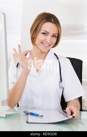 Portrait Of Happy Young Female Doctor Showing Ok Sign Stock Photo