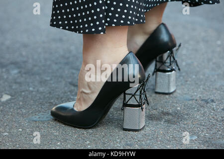 MILAN - SEPTEMBER 21: Woman with black leather high heel shoes with silver heel before Luisa Beccaria fashion show, Milan Fashion Week street style on Stock Photo