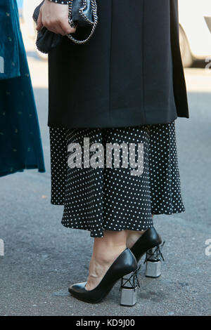 MILAN - SEPTEMBER 21: Woman with black and white polka dot skirt and black and silver high heel shoes before Luisa Beccaria fashion show, Milan Fashio Stock Photo