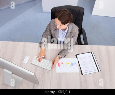 High Angle View Of Businesswoman Smiling Young Businesswoman At Desk Stock Photo