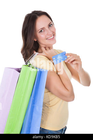 Smiling Woman With Shopping Bags Holding Credit Card Over White Background