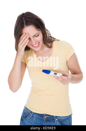 Portrait Of Worried Woman Looking At Pregnancy Result Over White Background Stock Photo