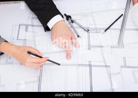 Closeup Of A Person's Hand Pointing On Blue Print Stock Photo