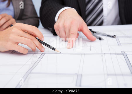 Closeup Of A Person's Hand Pointing On Blue Print Stock Photo