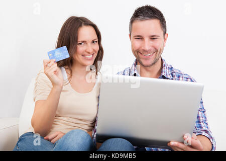 Portrait Of A Happy Young Couple Shopping Online With Credit Card Stock Photo