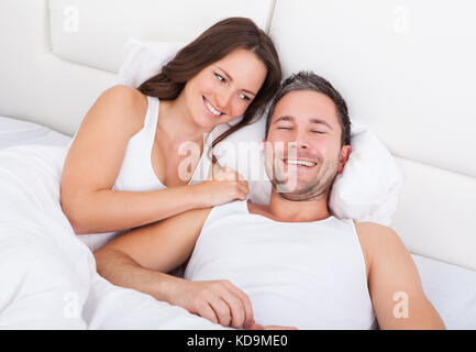 Happy Young Woman Looking At Man Sleeping Stock Photo