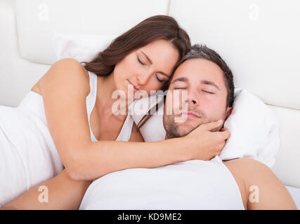 Young Couple Sleeping Side By Side On Bed Stock Photo
