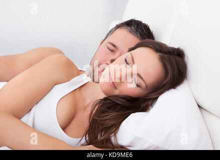 Young Couple Sleeping Side By Side On Bed Stock Photo