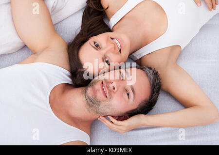 Portrait Of Happy Young Couple Lying On Back Stock Photo