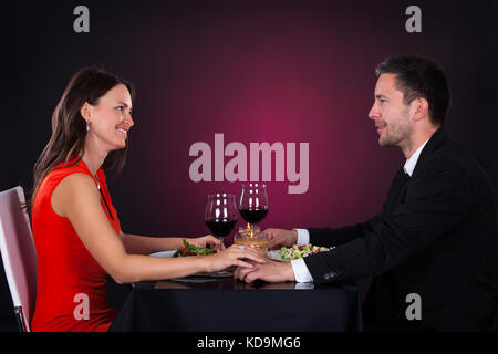 Young Smiling Couple Having Dinner With Wine Glass On Table Stock Photo