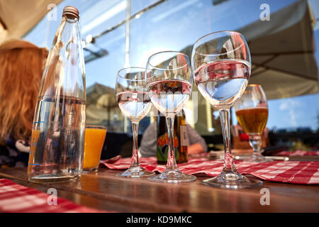 Row of pure drinking water glasses at summer terrace cafe. Stock Photo