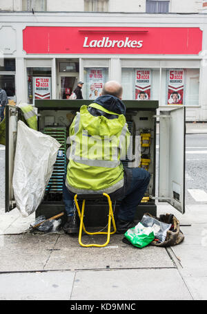 A BT Openreach Telecoms Engineer installing copper wire in a telecoms cabinet Stock Photo