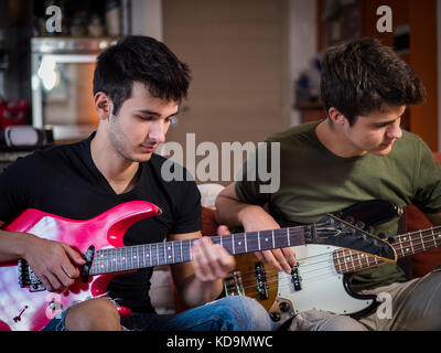 Young men playing electric guitars Stock Photo