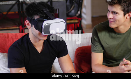 Cheerful men having fun with VR headset Stock Photo