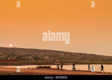 African rural people returning from work, with sunset. Sumbe. Angola. Stock Photo