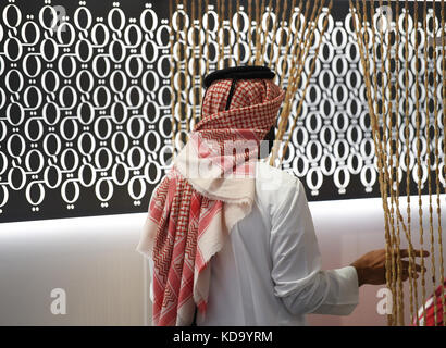 Frankfurt am Main, Germany. 11th Oct, 2017. An employee at the Qatar stand at Frankfurt Book Fair in Frankfurt am Main, Germany, 11 October 2017. The world's largest book fair runs until 15 October. Credit: Arne Dedert/dpa/Alamy Live News Stock Photo