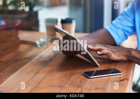 Young man working online at a sidewalk cafe counter Stock Photo