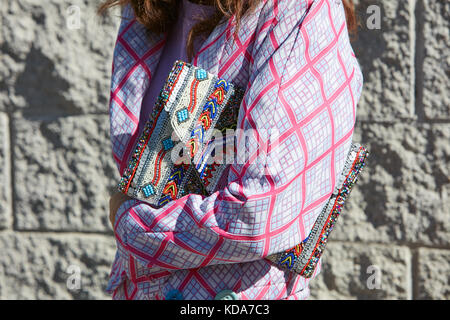 MILAN - SEPTEMBER 20: Woman with colorful beads decorated bag and pink and white checkered dress before Alberto Zambelli fashion show, Milan Fashion W Stock Photo