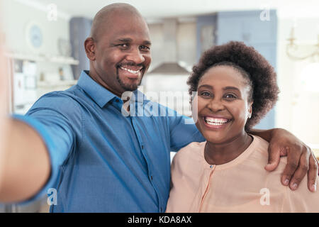 Smiling African couple taking a selfie together at home Stock Photo