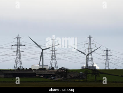 National Grid electricity transmission lines and pylons in front of wind turbines in Heysham, Lancashire, UK Stock Photo