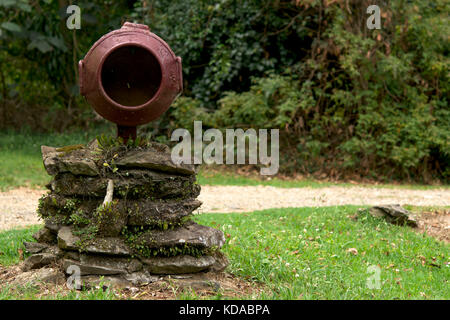 Rusty old rural rustic nostalgic round large milk barrel mail box on left with grass and forest background in summer day Stock Photo