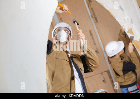 builders are using a chisel and hammer Stock Photo