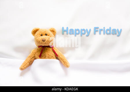 Teddy Bear lying with message '  Happy  Friday ' Stock Photo