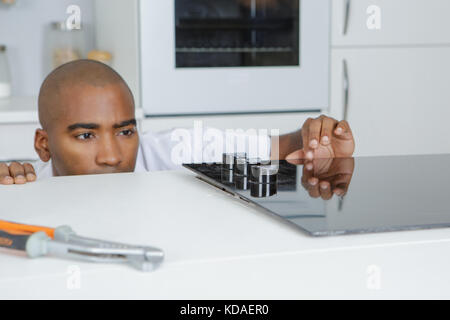 carpenter installing luxury fitted kitchen Stock Photo