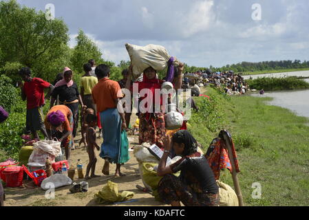 Hundreds of Rohingya people crossing Bangladesh's border as they flee from Buchidong at Myanmar after crossing the Nuf River in Taknuf, Bangladesh. Stock Photo