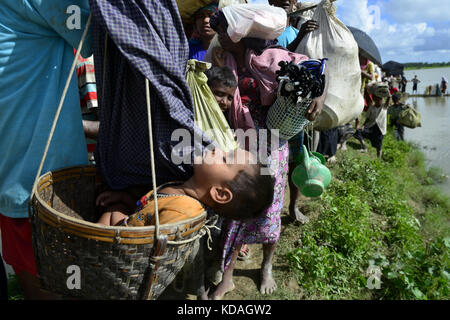 Hundreds of Rohingya people crossing Bangladesh's border as they flee from Buchidong at Myanmar after crossing the Nuf River in Taknuf, Bangladesh. Stock Photo