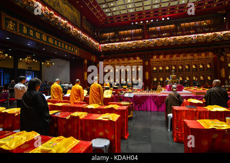 Singapore - Jun 12, 2017. Monks praying at Tooth Relic Temple in Singapore. The remarkable temple, in the heart of Singapore Chinatown, has much to in Stock Photo