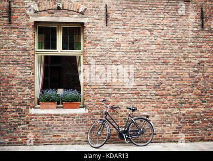 Bicycle parked outside shuttered windows Stock Photo
