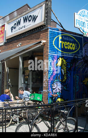 Dragon on wall in Kensington Place Toronto Canada cafe eating dog fish and chips eating art artwork bike cycle dragon eat food box sign signs outside Stock Photo