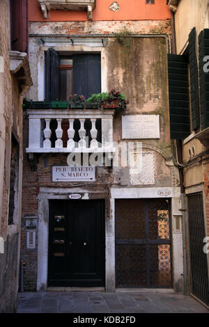 Narrow path between houses and buildings in Venice. With directions to san Marco and Rialto, Italy Stock Photo