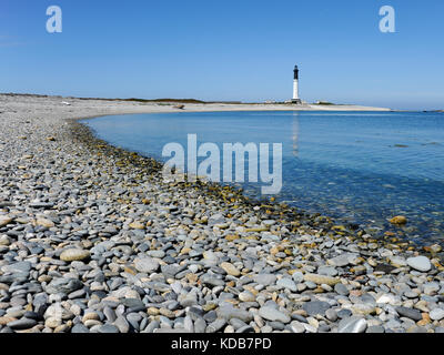 Gravel beach on Ile de Sein (France) with lighthouse in the background Stock Photo