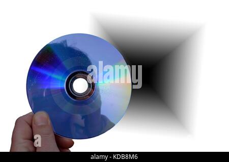 hand holding cd or dvd disc close up and black hole background Stock Photo