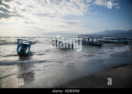 Secured boats against the increasing waves and tide in Gili Air, Gili Islands, Indonesia. Stock Photo