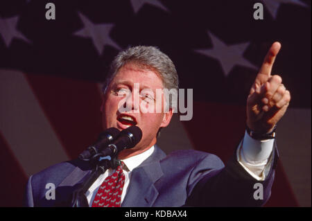 President Bill Clinton speaks under a giant American flag. Stock Photo